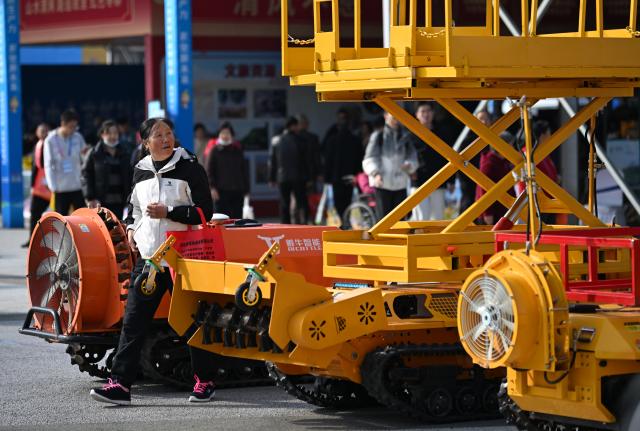 (251026) -- YANGLING, Oct. 26, 2025 (Xinhua) -- A visitor learns about a machine for orchard management during the 32nd China Yangling Agricultural Hi-Tech Fair in Yangling, northwest China's Shaanxi Province, Oct. 26, 2025. The agricultural hi-tech fair kicked off here on Saturday, highlighting a competition for agricultural robots as well as an exhibition on smart agricultural machinery. (Xinhua/Li Yibo)