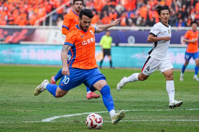 (251026) -- JINAN, Oct. 26, 2025 (Xinhua) -- Valeri Qazaishvili (front) of Shandong Taishan shoots during the 28th round match between Shandong Taishan and Shanghai Port at the 2025 Chinese Super League (CSL) in Jinan, east China's Shandong Province, Oct. 26, 2025. (Xinhua/Zhu Zheng)
