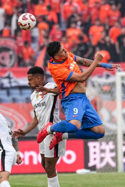 (251026) -- JINAN, Oct. 26, 2025 (Xinhua) -- Cryzan Barcelos (R) of Shandong Taishan vies for a header during the 28th round match between Shandong Taishan and Shanghai Port at the 2025 Chinese Super League (CSL) in Jinan, east China's Shandong Province, Oct. 26, 2025. (Xinhua/Zhu Zheng)