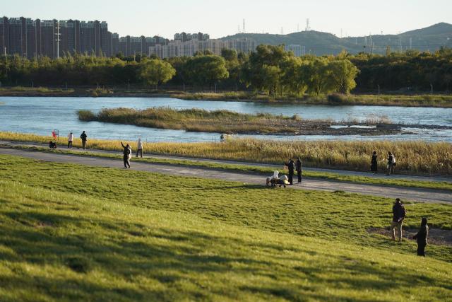 (251026) -- BEIJING, Oct. 26, 2025 (Xinhua) -- People enjoy themselves by the Yongding River in Shijingshan District of Beijing, capital of China, Oct. 26, 2025. (Xinhua/Zhang Chenlin)