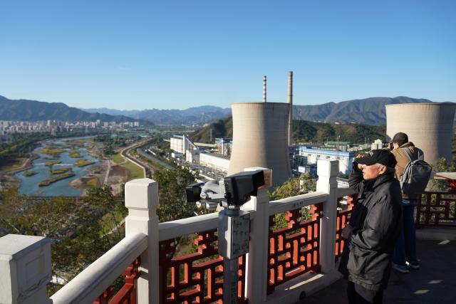 (251026) -- BEIJING, Oct. 26, 2025 (Xinhua) -- People enjoy the scenery along the Yongding River from a viewing platform in Shijingshan District of Beijing, capital of China, Oct. 26, 2025. (Xinhua/Zhang Chenlin)
