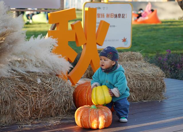 (251026) -- BEIJING, Oct. 26, 2025 (Xinhua) -- A kid plays at a market by the Yongding River in Shijingshan District of Beijing, capital of China, Oct. 26, 2025. (Xinhua/Zhang Chenlin)