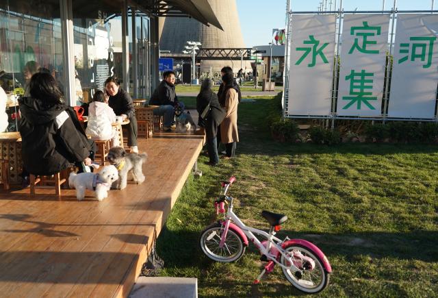 (251026) -- BEIJING, Oct. 26, 2025 (Xinhua) -- People enjoy themselves at a market by the Yongding River in Shijingshan District of Beijing, capital of China, Oct. 26, 2025. (Xinhua/Zhang Chenlin)