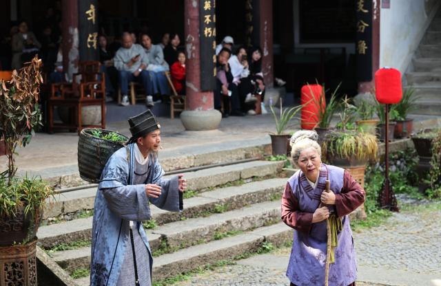 (251026) -- QUZHOU, Oct. 26, 2025 (Xinhua) -- Performers are seen during a performance themed on filial responsibility in Dachen Village of Quzhou, east China's Zhejiang Province, Oct. 25, 2025. In recent years, Quzhou has been fostering a harmonious living environment by promoting Chinese etiquette education to the public and putting the idea of "good-mannered" into its governmental service. (Xinhua/Jin Haoyuan)