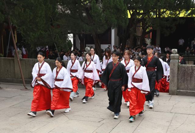 (251026) -- QUZHOU, Oct. 26, 2025 (Xinhua) -- Students pay tribute to teachers at Nanzong Confucius Temple in Quzhou, east China's Zhejiang Province, Oct. 26, 2025. In recent years, Quzhou has been fostering a harmonious living environment by promoting Chinese etiquette education to the public and putting the idea of "good-mannered" into its governmental service. (Xinhua/Jin Haoyuan)