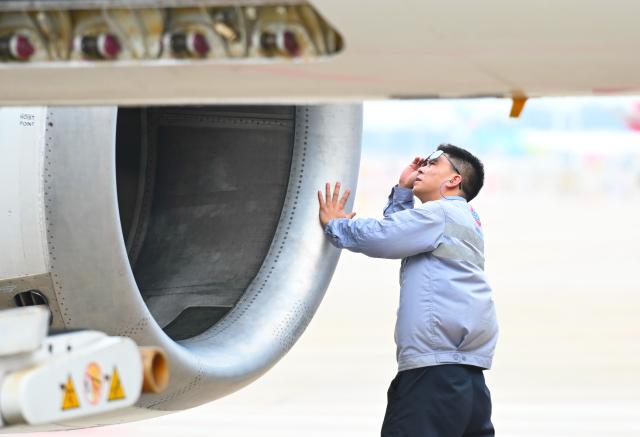 (251026) -- FUZHOU, Oct. 26, 2025 (Xinhua) -- A staff member checks the security condition of an airplane at the Fuzhou Changle International Airport in Fuzhou, southeast China's Fujian Province, Oct. 26, 2025. Fujian's first flight granted the Fifth Freedom of the Air, the "Phnom Penh-Fuzhou-Tokyo" route, was officially launched on Sunday. The Fifth Freedom of the Air refers to the right granted to an airline of one country to make a stopover in a third country while operating an international route, allowing it to load and unload passengers and cargo there. (Xinhua/Lin Shanchuan)