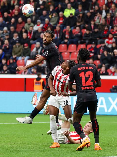 (251027) -- LEVERKUSEN, Oct. 27, 2025 (Xinhua) -- Loic Bade (top) of Bayer 04 Leverkusen heads for the ball during the first division of Bundesliga football match between Bayer 04 Leverkusen and SC Freiburg in Leverkusen, Germany, Oct. 26. 2025. (Photo by Joachim Bywaletz/Xinhua)