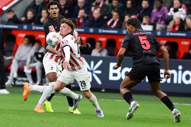 (251027) -- LEVERKUSEN, Oct. 27, 2025 (Xinhua) -- Loic Bade (R, front) of Bayer 04 Leverkusen vies with Philipp Treu (L, front) of SC Freiburg during the first division of Bundesliga football match between Bayer 04 Leverkusen and SC Freiburg in Leverkusen, Germany, Oct. 26. 2025. (Photo by Joachim Bywaletz/Xinhua)