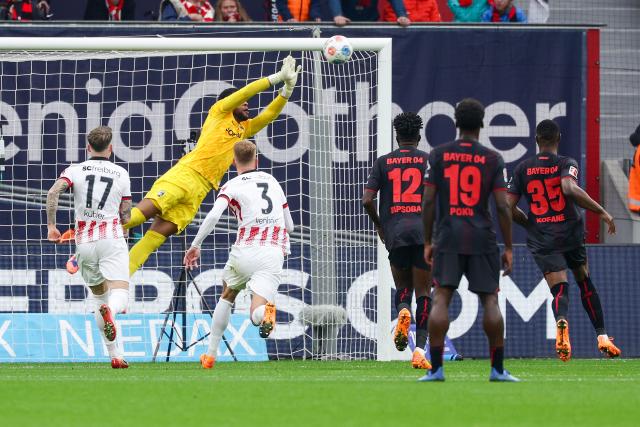 (251027) -- LEVERKUSEN, Oct. 27, 2025 (Xinhua) -- Goalkeeper of SC Freiburg Noah Atubolu (rear) makes a save during the first division of Bundesliga football match between Bayer 04 Leverkusen and SC Freiburg in Leverkusen, Germany, Oct. 26. 2025. (Photo by Joachim Bywaletz/Xinhua)