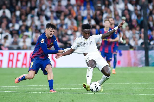 (251027) -- MADRID, Oct. 27, 2025 (Xinhua) -- Vinicius Junior (R) of Real Madrid vies with Pedri of Barcelona during the La Liga football match between Real Madrid and FC Barcelona at Santiago Bernabeu Stadium in Madrid, Spain, on Oct. 26, 2025. (Photo by Gustavo Valiente/Xinhua)