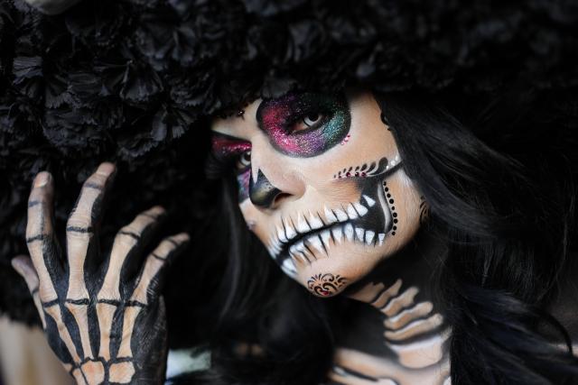 (251027) -- MEXICO CITY, Oct. 27, 2025 (Xinhua) -- A participant with facial makeup takes part in the Catrinas Parade in Mexico City, capital of Mexico, on Oct. 26, 2025. The Catrinas Parade was held on Sunday ahead of the Day of the Dead. (Photo by Francisco Canedo/Xinhua)