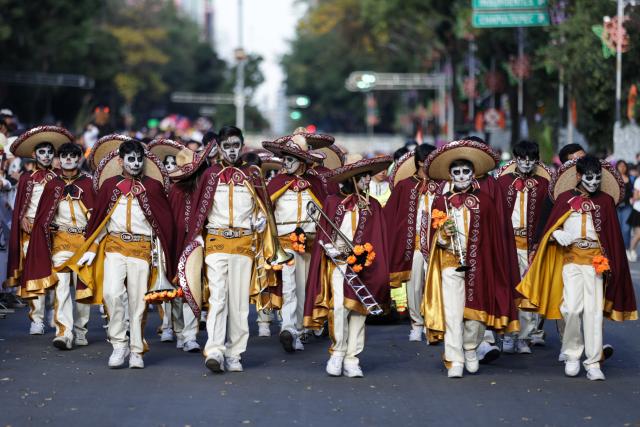 (251027) -- MEXICO CITY, Oct. 27, 2025 (Xinhua) -- People with facial makeup take part in the Catrinas Parade in Mexico City, capital of Mexico, on Oct. 26, 2025. The Catrinas Parade was held on Sunday ahead of the Day of the Dead. (Photo by Francisco Canedo/Xinhua)