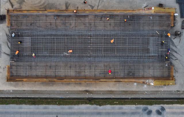 (251027) -- RUGAO, Oct. 27, 2025 (Xinhua) -- A drone photo shows workers operating at the beam fabrication site of the Shanghai-Nanjing section along the Shanghai-Chongqing-Chengdu High-speed Railway in Banjing Township of Rugao, east China's Jiangsu Province, Oct. 27, 2025. The box girder prefabrication work at this site has entered its final phase. (Xinhua/Ji Chunpeng)