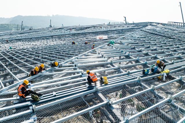 (251027) -- XI'AN, Oct. 27, 2025 (Xinhua) -- A drone photo taken on Oct. 27, 2025 shows constructors working at the construction site of Xi'an East Station in Xi'an, northwest China's Shaanxi Province. The main structure of the Xi'an East Station building has been successfully completed on Monday. Serving as a comprehensive transportation hub integrating high-speed railway, conventional railway, metro, and bus services systems, the station is expected to handle an annual passenger volume of 36.5 million once it officially opens. (Photo by Liu Xiang/Xinhua)
