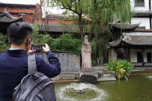 (251027) -- CHONGQING, Oct. 27, 2025 (Xinhua) -- People takes photos of a statue of Liu Yuxi, a Chinese poet in the Tang Dynasty (618-907), at the ancient town of Baidi in Fengjie County, southwest China's Chongqing Municipality, Oct. 27, 2025. Fengjie, a county in Chongqing where the Kuimen gateway to the magnificent gorges of the Yangtze River is located, gained its reputation as the "city of poetry," as poets, military figures and politicians in history wrote extensively about the forbidding landscape of rapid currents and narrow waterways. 
  In recent years, the county has made full use of its ecological, cultural and historical advantages, aiming to build itself into a world-class tourist destination. (Xinhua/Zhou Jiayi)