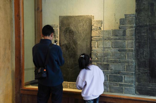 (251027) -- CHONGQING, Oct. 27, 2025 (Xinhua) -- People look at an exhibit at the ancient town of Baidi in Fengjie County, southwest China's Chongqing Municipality, Oct. 27, 2025. Fengjie, a county in Chongqing where the Kuimen gateway to the magnificent gorges of the Yangtze River is located, gained its reputation as the "city of poetry," as poets, military figures and politicians in history wrote extensively about the forbidding landscape of rapid currents and narrow waterways. 
  In recent years, the county has made full use of its ecological, cultural and historical advantages, aiming to build itself into a world-class tourist destination. (Xinhua/Zhou Jiayi)