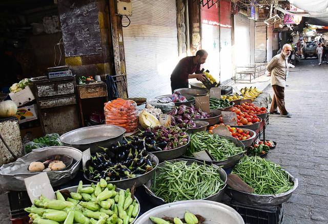 (251027) -- DAMASCUS, Oct. 27, 2025 (Xinhua) -- A vendor arranges fresh vegetables and fruits at a market in Damascus, Syria, Oct. 27, 2025. (Photo by Ammar Safarjalani/Xinhua)