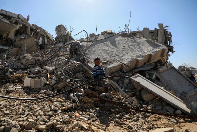 (251027) -- GAZA, Oct. 27, 2025 (Xinhua) -- A palestinian boy is seen at a street with destroyed buildings, in Jabalia refugee camp northern Gaza Strip, Oct. 27, 2025. The United Nations estimates that approximately 92 percent of all residential buildings in Gaza -- around 436,000 homes -- have been damaged or destroyed since the start of the conflict. (Photo by Rizek Abdeljawad/Xinhua)