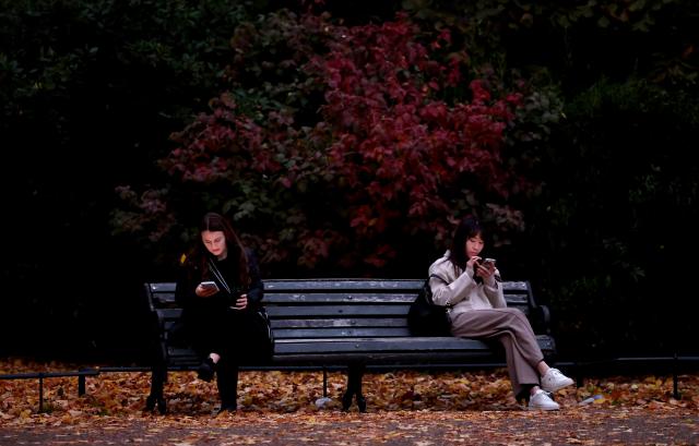 (251028) -- LONDON, Oct. 28, 2025 (Xinhua) -- People rest at a bench in Regent's Park in London, Britain, Oct. 27, 2025. (Xinhua/Li Ying)