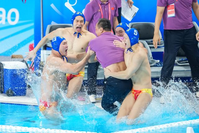 (251028) -- BEIJING, Oct. 28, 2025 (Xinhua) -- Players and coach of Guangdong team celebrate after winning the men's water polo gold medal match between Guangdong and Shanghai at China's 15th National Games in Guangzhou, south China's Guangdong Province, Oct. 27, 2025. (Xinhua/Chen Sihan)