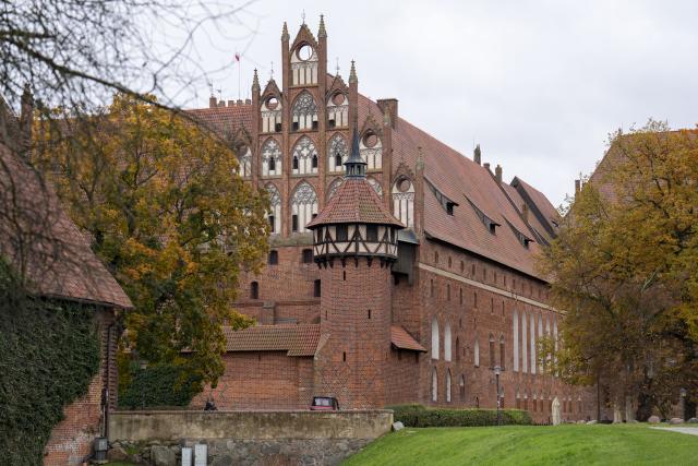 (251028) -- MALBORK, Oct. 28, 2025 (Xinhua) -- This photo taken on Oct. 27, 2025 shows a view of the Malbork Castle in Malbork, Poland. The Malbork Castle, also known as the Castle of the Teutonic Order, was built by the Teutonic Knights in the 13th century. The red-brick fortress covers about 200,000 square meters, making it one of the world's largest brick castles and a masterpiece of medieval Gothic military architecture. It was inscribed on the UNESCO World Heritage List in 1997 for its outstanding cultural and architectural value. (Xinhua/Xia Yuanyi)