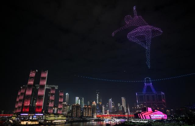(251028) -- CHONGQING, Oct. 28, 2025 (Xinhua) -- This photo shows a drone light show in Nan'an District of southwest China's Chongqing Municipality, Oct. 27, 2025. A grand drone light show themed on "People-Centered Smart Cities Towards the Future" was staged here on Monday as a special event for the 2025 World Cities Day China Observance. (Xinhua/Chen Cheng)