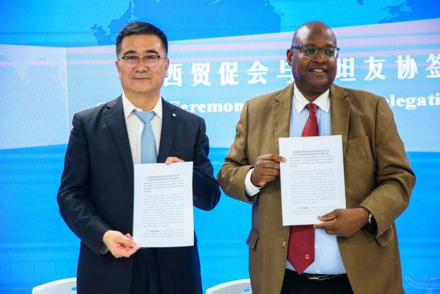 (251028) -- DAR ES SALAAM, Oct. 28, 2025 (Xinhua) -- Quan Jian (L), head of the Shaanxi economic and trade delegation, and Joseph Simbakalia, board member of the Tanzania-China Friendship Promotion Association, pose for a photo in Dar es Salaam, Tanzania, Oct. 27, 2025. TO GO WITH "Tanzania seeks to strengthen economic cooperation with China's Shaanxi Province" (Xinhua/Emmanuel Herman)