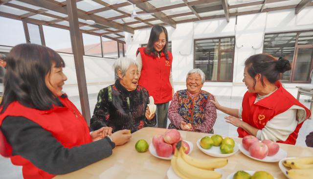 (251028) -- BEIJING, Oct. 28, 2025 (Xinhua) -- Volunteers chat with elderly people at a nursing home in Zhanggezhuang Village of Zunhua City, north China's Hebei Province, Oct. 28, 2025. A series of activities were held across the country to mark China's Chongyang Festival, which will fall on Oct. 29 this year. Also known as Seniors' Day in China nowadays, it highlights the public's care for elderly people. (Photo by Liu Mancang/Xinhua)
