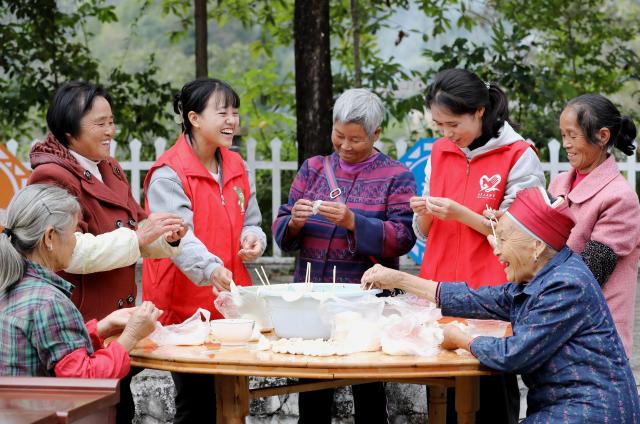 (251028) -- BEIJING, Oct. 28, 2025 (Xinhua) -- Volunteers make dumplings together with elderly people in Gaobei Village of Shibing County, Qiandongnan Miao and Dong Autonomous Prefecture, southwest China's Guizhou Province, Oct. 27, 2025. A series of activities were held across the country to mark China's Chongyang Festival, which will fall on Oct. 29 this year. Also known as Seniors' Day in China nowadays, it highlights the public's care for elderly people. (Photo by Tai Shengzhi/Xinhua)