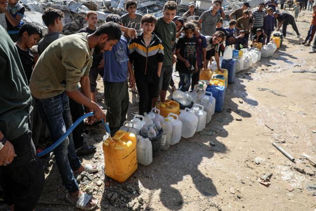 (251028) -- GAZA, Oct. 28, 2025 (Xinhua) -- Palestinians queue in the Shati refugee camp, west of Gaza City, to fill up on water, Oct. 28, 2025. Palestinians may have to wait hours for a small amount of water, which is largely unavailable due to damage to water networks caused by Israeli bombing during the war. (Photo by Rizek Abdeljawad/Xinhua)
