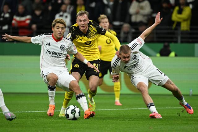(251029) -- FRANKFURT, Oct. 29, 2025 (Xinhua) -- Doan Ritsu (L), Rasmus Kristensen (R) of Eintracht Frankfurt vie with Maximilian Beier of Borussia Dortmund during the German Cup football second round match between Eintracht Frankfurt and Borussia Dortmund in Frankfurt, Germany, Oct. 28, 2025. (Photo by Ulrich Hufnagel/Xinhua)