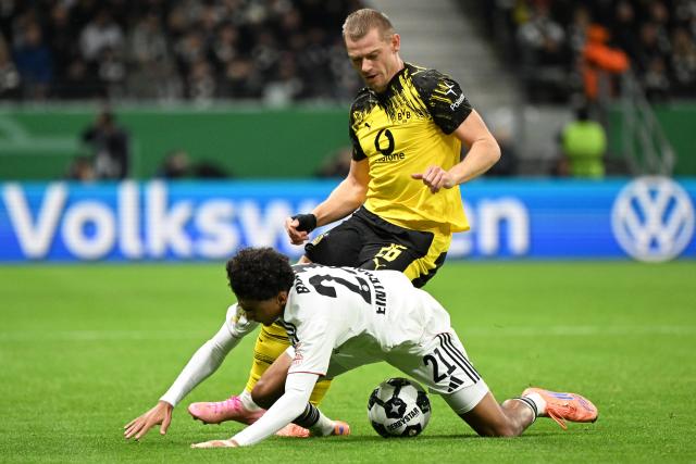 (251029) -- FRANKFURT, Oct. 29, 2025 (Xinhua) -- Nathaniel Brown (bottom) of Eintracht Frankfurt vies with Julian Ryerson of Borussia Dortmund during the German Cup football second round match between Eintracht Frankfurt and Borussia Dortmund in Frankfurt, Germany, Oct. 28, 2025. (Photo by Ulrich Hufnagel/Xinhua)