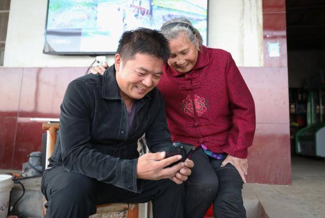 (251029) -- TONGCHENG, Oct. 29, 2025 (Xinhua) -- Dai Shuying (R) watches short videos with her grandson Wang Tiantian in Laomei Village of Xindu Town, Tongcheng City, east China's Anhui Province, Oct. 22, 2025. The 82-year-old Dai Shuying lives with her eldest son and grandson in Laomei Village. Although she doesn't do much farm work now, she occasionally uses a drone to help to spray pesticides and fertilizers for the corps under the guidance of her grandson Wang Tiantian.
   Accompanied by Wang, she also promotes and sells agricultural products such as rice and oil through live streaming, and enjoys shooting videos with him. Watching the interaction between them during the live streaming on the mobile phone is a happy time for the whole family. (Xinhua/Du Xiaoyi)
