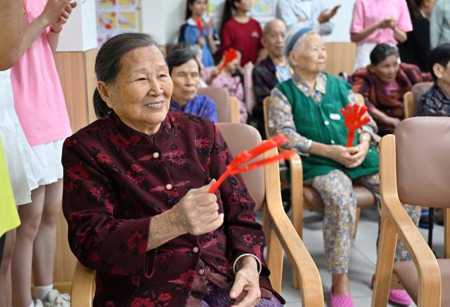 (251029) -- BEIJING, Oct. 29, 2025 (Xinhua) -- Some elderly people watch performances from volunteers at an elderly care service center in Qiongshan District of Haikou, south China's Hainan Province, Oct. 29, 2025.
  A series of celebration activities were held across the country to mark Chongyang Festival, which falls on Oct. 29 this year. Also known as China's Seniors' Day, it honors the country's traditional virtues of filial piety and family love. (Xinhua/Guo Cheng)
