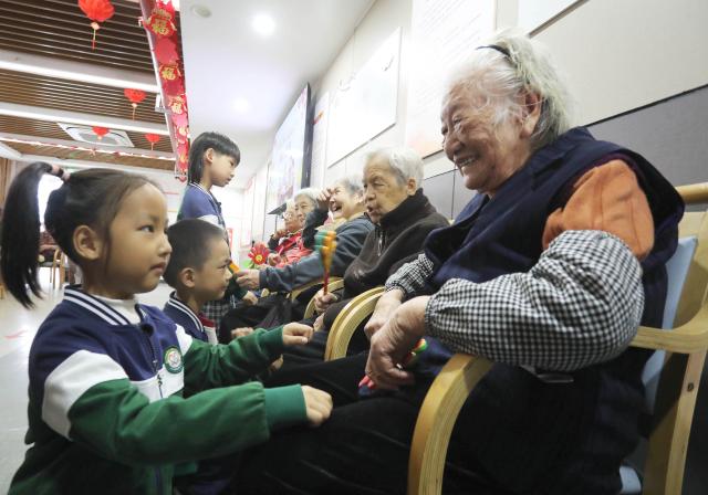 (251029) -- BEIJING, Oct. 29, 2025 (Xinhua) -- Kindergarten children pay a visit to senior citizens at an apartment for the elderly in Suzhou City, east China's Jiangsu Province, Oct. 29, 2025. A series of celebration activities were held across the country to mark Chongyang Festival, which falls on Oct. 29 this year. Also known as China's Seniors' Day, it honors the country's traditional virtues of filial piety and family love. (Photo by Hang Xingwei/Xinhua)