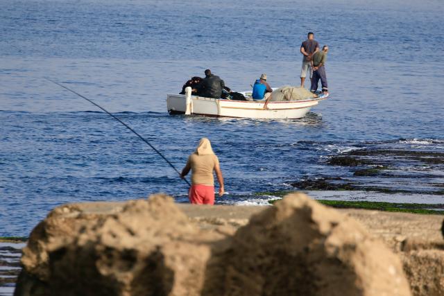 (251029) -- SIDON, Oct. 29, 2025 (Xinhua) -- People fish on the beach of Sidon, southern Lebanon, Oct. 29, 2025. (Photo by Ali Hashisho/Xinhua)