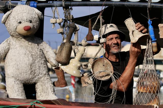 (251029) -- SIDON, Oct. 29, 2025 (Xinhua) -- A fisherman displays old holdings found deep in the sea in Sidon, southern Lebanon, Oct. 29, 2025. (Photo by Ali Hashisho/Xinhua)