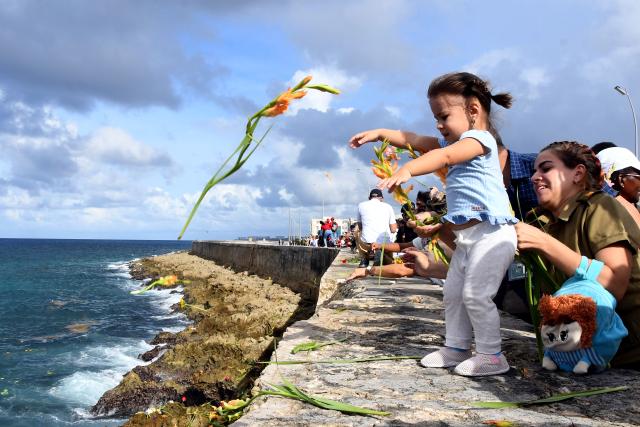 (251029) -- HAVANA, Oct. 29, 2025 (Xinhua) -- A girl throws a flower into the sea during a ceremony commemorating Camilo Cienfuegos in Havana, capital of Cuba, on Oct. 28, 2025. Cubans gathered at seaside to offer flowers to commemorate Camilo Cienfuegos on Tuesday. Cuba marked the 66th anniversary of the death of Camilo Cienfuegos. Camilo, along with Fidel Castro and Che Guevara, are the three chief commanders of the Cuban revolution. He died in a flight accident at the age of 27. (Photo by Xinhua/Joaquin Hernandez)