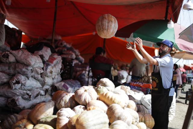 (251029) -- MEXICO CITY, Oct. 29, 2025 (Xinhua) -- A vendor unloads pumpkin ahead of Day of the Dead celebrations, at the central de Abasto market in Mexico City, Oct. 29, 2025. (Photo by Francisco Canedo/Xinhua)