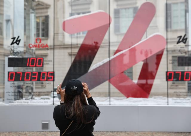 (251030) -- MILAN, Oct. 30, 2025 (Xinhua) -- A woman takes a photo of the digital countdown timer of Milano-Cortina 2026 Olympic Games in Milan, Italy, Oct. 29, 2025. A ceremony marking 100 days to the opening of the Milano-Cortina 2026 Olympic Winter Games was held at Palazzo Lombardia in Milan, where organizers unveiled the official podiums for the Olympic and Paralympic Games and introduced 12 "digital torchbearers", symbolizing the start of the final stage of preparations for the event. (Xinhua/Li Jing)
