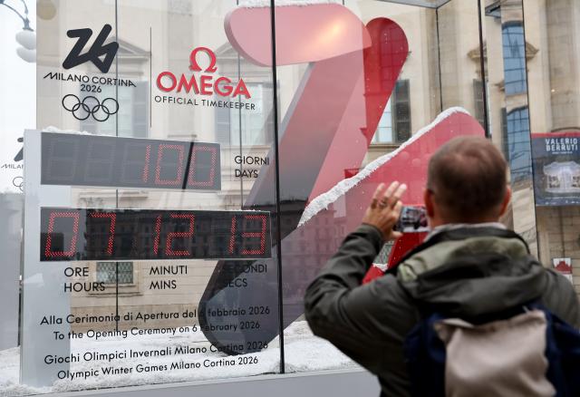 (251030) -- MILAN, Oct. 30, 2025 (Xinhua) -- A man takes a photo of the digital countdown timer of Milano-Cortina 2026 Olympic Games in Milan, Italy, Oct. 29, 2025. A ceremony marking 100 days to the opening of the Milano-Cortina 2026 Olympic Winter Games was held at Palazzo Lombardia in Milan, where organizers unveiled the official podiums for the Olympic and Paralympic Games and introduced 12 "digital torchbearers", symbolizing the start of the final stage of preparations for the event. (Xinhua/Li Jing)