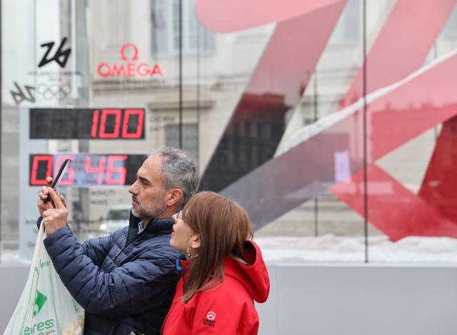 (251030) -- MILAN, Oct. 30, 2025 (Xinhua) -- People take a photo with the digital countdown timer of Milano-Cortina 2026 Olympic Games in Milan, Italy, Oct. 29, 2025. A ceremony marking 100 days to the opening of the Milano-Cortina 2026 Olympic Winter Games was held at Palazzo Lombardia in Milan, where organizers unveiled the official podiums for the Olympic and Paralympic Games and introduced 12 "digital torchbearers", symbolizing the start of the final stage of preparations for the event. (Xinhua/Li Jing)
