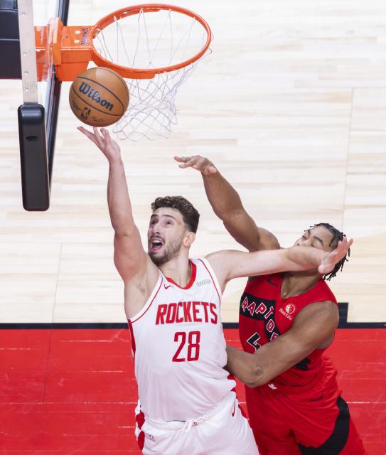 (251030) -- TORONTO, Oct. 30, 2025 (Xinhua) -- Alperen Sengun (L) of Houston Rockets goes for a lay-up during the 2025-2026 NBA regular season game between Toronto Raptors and Houston Rockets in Toronto, Canada, on Oct. 29, 2025. (Photo by Zou Zheng/Xinhua)