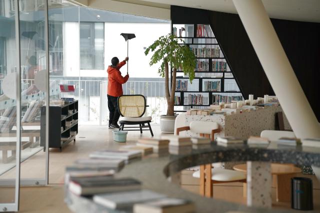 (251030) -- ANKANG, Oct. 30, 2025 (Xinhua) -- A staff member works at the library of a hotel in Guoqing Village of Zhenping County, Ankang City, northwest China's Shaanxi Province, Oct. 29, 2025. Zhenping County, with a forest coverage rate of 88.82 percent, has leveraged its natural resources in recent years to develop healthcare tourism industry, boosting local economy. (Xinhua/Shao Rui)