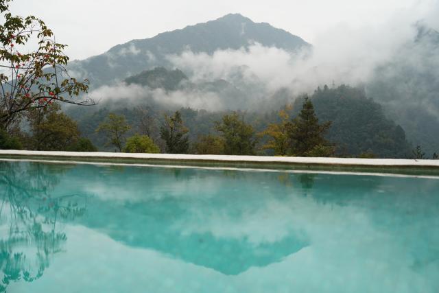(251030) -- ANKANG, Oct. 30, 2025 (Xinhua) -- This photo taken on Oct. 29, 2025 shows a view of a pool and the surrounding scenery at a hotel in Guoqing Village of Zhenping County, Ankang City, northwest China's Shaanxi Province. Zhenping County, with a forest coverage rate of 88.82 percent, has leveraged its natural resources in recent years to develop healthcare tourism industry, boosting local economy. (Xinhua/Shao Rui)