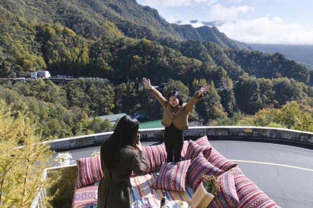 (251030) -- ANKANG, Oct. 30, 2025 (Xinhua) -- An aerial drone photo taken on Oct. 30, 2025 shows tourists taking photos at the balcony of a cafe on Hualong Mountain in Zhenping County, Ankang City, northwest China's Shaanxi Province. Zhenping County, with a forest coverage rate of 88.82 percent, has leveraged its natural resources in recent years to develop healthcare tourism industry, boosting local economy. (Xinhua/Shao Rui)
