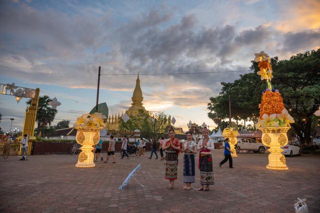 (251030) -- VIENTIANE, Oct. 30, 2025 (Xinhua) -- Three women pose for photo on That Luang Square in Vientiane, capital of Laos, Oct. 30, 2025. TO GO WITH: "Feature: Laos in full swing to welcome golden glow of That Luang festival " (Photo by Kaikeo Saiyasane/Xinhua)