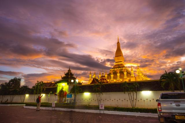 (251030) -- VIENTIANE, Oct. 30, 2025 (Xinhua) -- A man takes photo on That Luang Square in Vientiane, capital of Laos, Oct. 30, 2025. TO GO WITH: "Feature: Laos in full swing to welcome golden glow of That Luang festival " (Photo by Kaikeo Saiyasane/Xinhua)