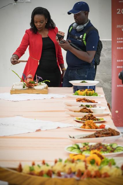 (251030) -- NAIROBI, Oct. 30, 2025 (Xinhua) -- Visitors take photos of Chinese dishes prepared by contestants during the 2025 Africa Championship of Chinese Cuisine held in Nairobi, Kenya, Oct. 30, 2025. The 2025 Africa Championship of Chinese Cuisine, the first of its kind on the continent, was held Thursday in the Kenyan capital Nairobi, highlighting the deepening cultural exchanges between China and Kenya. (Xinhua/Li Yahui)