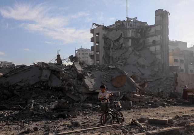 (251030) -- GAZA, Oct. 30, 2025 (Xinhua) -- A Palestinian boy is seen near destroyed houses after Israeli airstrikes, in west of Gaza City, Oct. 29, 2025. At least 100 Palestinians were killed in Israeli attacks across the Gaza Strip from late Tuesday to Wednesday, marking the most intense escalation since the ceasefire agreement took effect on October 10. (Photo by Rizek Abdeljawad/Xinhua)
